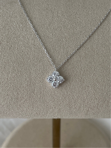Silver necklace with a diamond pendant on a beige stand