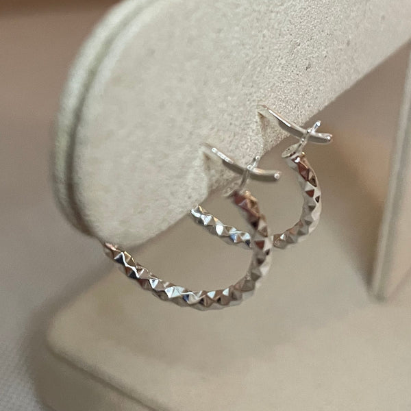 Silver earrings on a white surface