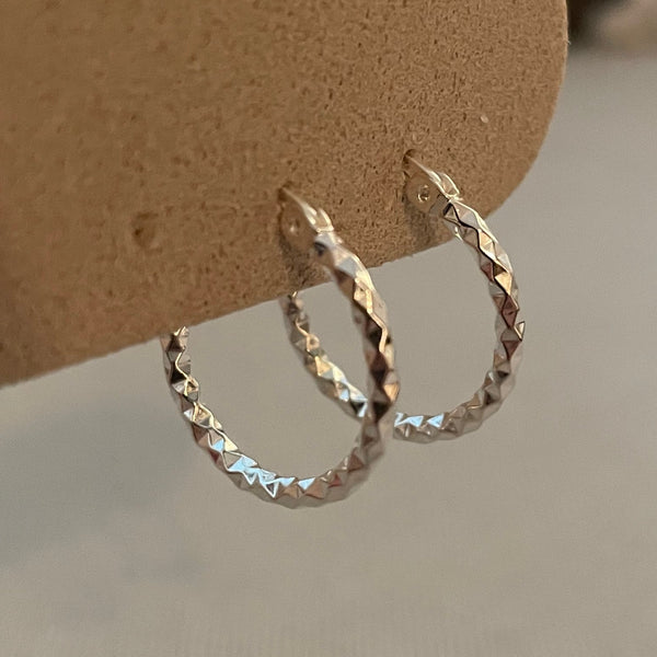 Silver ring on a cardboard stand with a neutral background