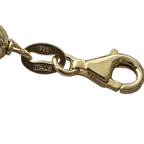 Gold charm with a lobster clasp on a textured gray background