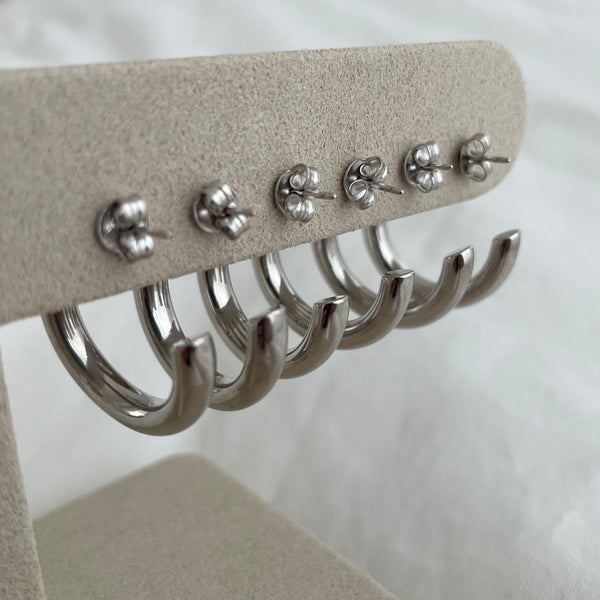 Row of sterling silver hoop earrings on jewellery stand showing the back butterfly 