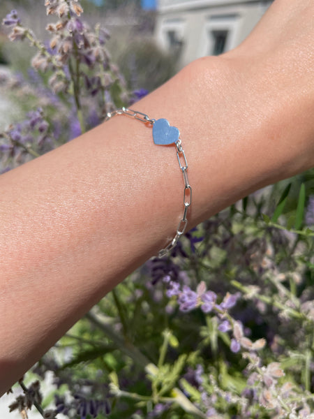 Sterling Silver paperclip bracelet with heart charm worn on someone's wrist with purple lavender garden in the background