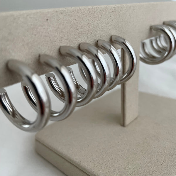 Row of sterling silver hoop earrings on jewellery stand