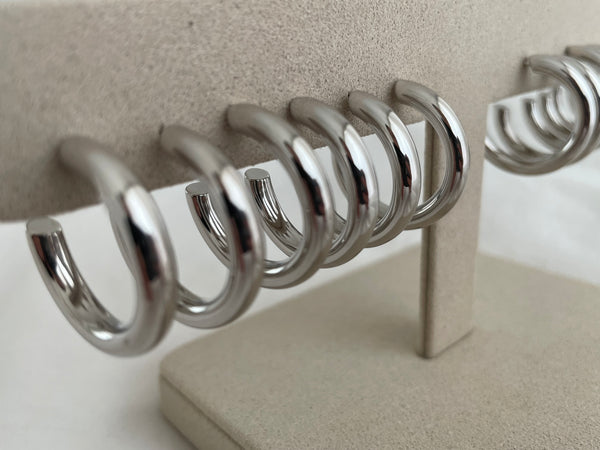 Row of sterling silver hoop earrings on jewellery stand