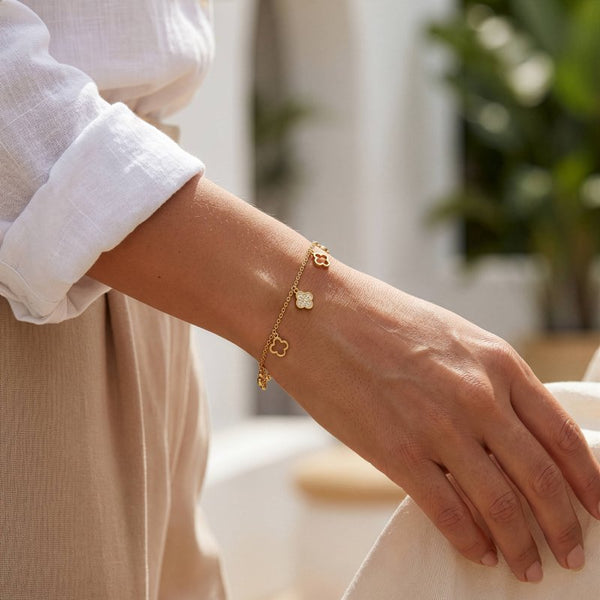 Gold bracelet on a wrist with a blurred indoor background