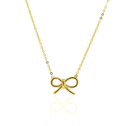 Gold bow-shaped pendant on a chain against a white background
