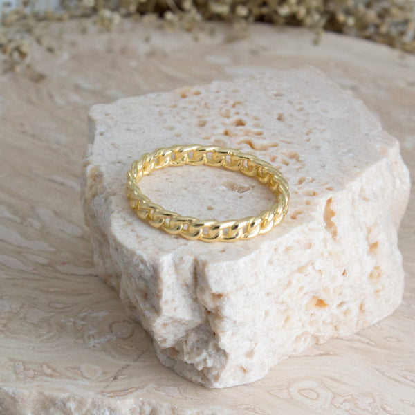 Gold ring on a textured stone surface with a natural background