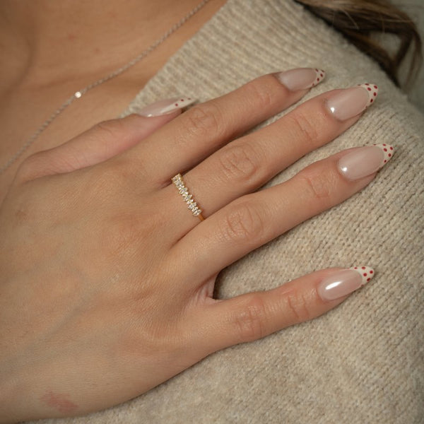 Hand wearing a diamond ring with a neutral background
