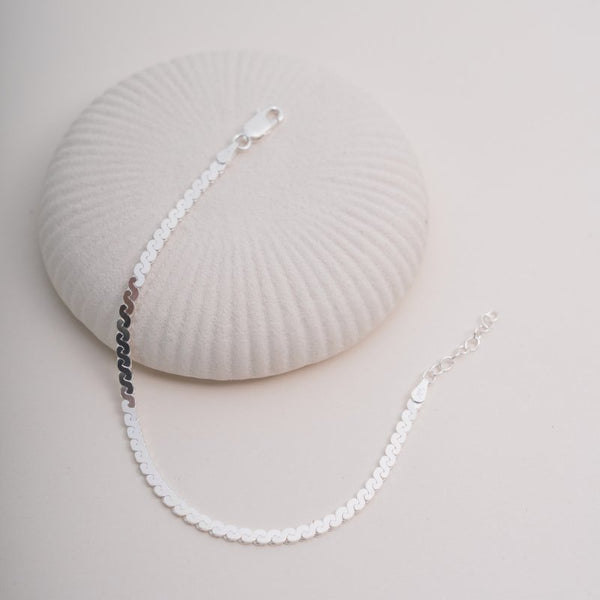 Pearl necklace on a light gray background with a shell