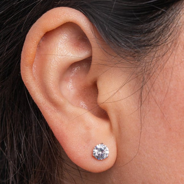 Close-up of an ear wearing a diamond stud earring.